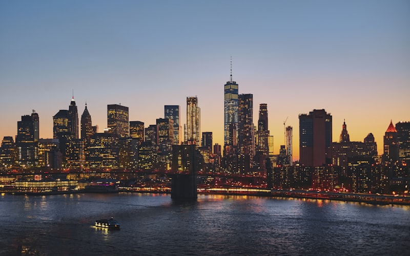 Manhattan skyline at dusk with the Brooklyn Bridge in the foreground